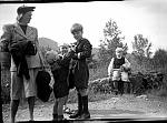 CW1033.jpg      Aslaug Blix (f. Våtvik) med barna Roald, Helge (bak) og Sigbjørn (holder en kattunge). Bjarne Waatvik sitter på berget.  Utenfor butikken i Våtvik. Sist på 1940 tallet.