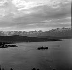 CW1362b.jpg    Litt av Ørnes, Korsnes, Åsen , Glomneset,<br>Glomfjella i bakgrunnen. Hurtigruta på tur fra Ørnes.