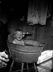 CW2481.jpg   Hans Julius Waatvik tar seg et bad i baljen .Bildet er tatt i 1939.  Vannet måtte bæres inn, varmes på vedkomfyren og bæres ut etter bruk.