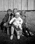 CW2484.jpg   Bildet er tatt utenfor gammelstua i Våtvika 1939.   Fra v.: Elsa Hansen (søster til Kåre Blix), Reidun med Hans Julius på fanget og Ingrid , (alle Waatvik)